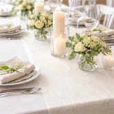 Elegant festbord dækket med råhvid Sizoweb bordløber, hvide blomster og levende lys