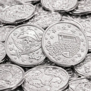 Close-up af sølvmønter i plast med piratmotiv – 3,8 cm mønter med skattekiste og dødningehoved til piratfest og skattejagt