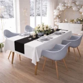 Elegant festbord dækket med hvid Sovie airlaid papirdug, sort bordløber, blomsterdekoration og levende lys