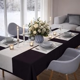 Elegant pyntet festbord med sort Sovie Airlaid papirdug og lys bordløber, dækket med service, stearinlys