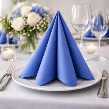 Blå Sovie Linclass Airlaid serviet foldet på tallerken ved elegant festbord med glas, blomster og stearinlys