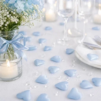 Stemningsbillede med lyseblå stof hjerter som romantisk bordpynt til bryllup, barnedåb og babyshower