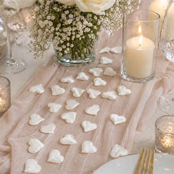 Store creme stof hjerter som romantisk bordpynt til bryllup og elegant borddekoration med lys og blomster