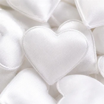 Close-up af store hvide stofhjerter i satinlook til bryllup, konfirmation og romantisk bordpynt