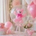 Transparent ballon med lyserød latex ballonbamse indeni som dekoration til pige babyshower, barnedåb og fejring af en nyfødt pige.